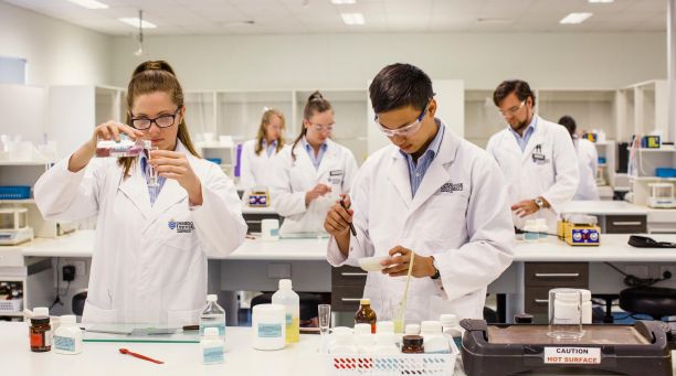 2 people in lab coats handling samples