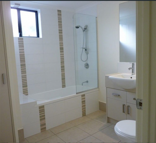 A bathroom with a large tub and low toilet. 